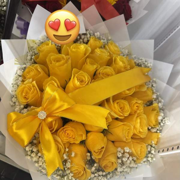 Bouquet of yellow roses with a satin ribbon and white filler flowers