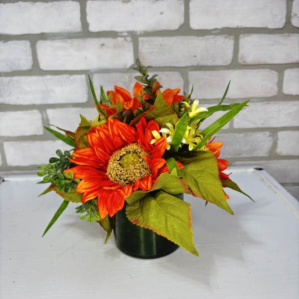 Orange sunflower arrangement in a dark vase