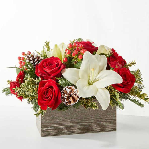 Red roses and a white lily arranged in a rectangular box