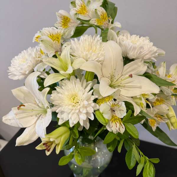 White lilies and chrysanthemums in a glass vase