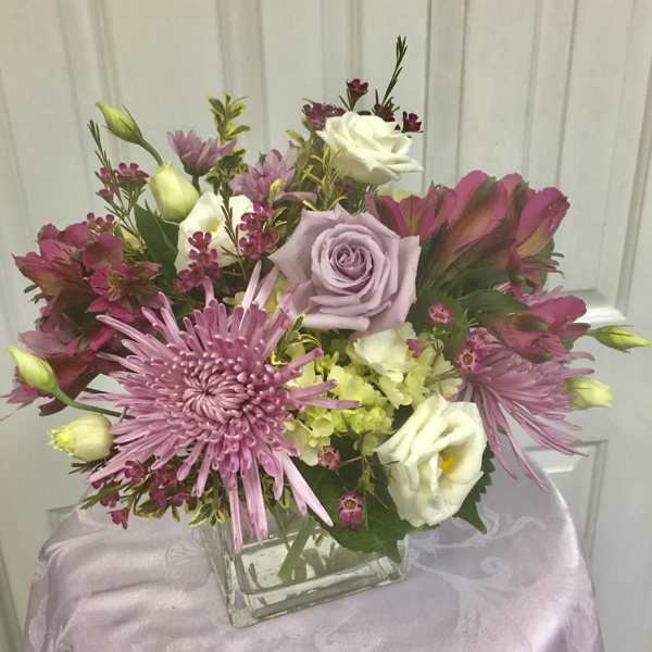 Bouquet of pink and white flowers in a square glass vase
