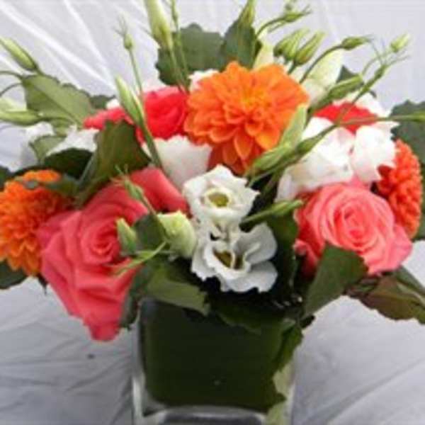 Bouquet of pink, orange, and white flowers in a dark vase