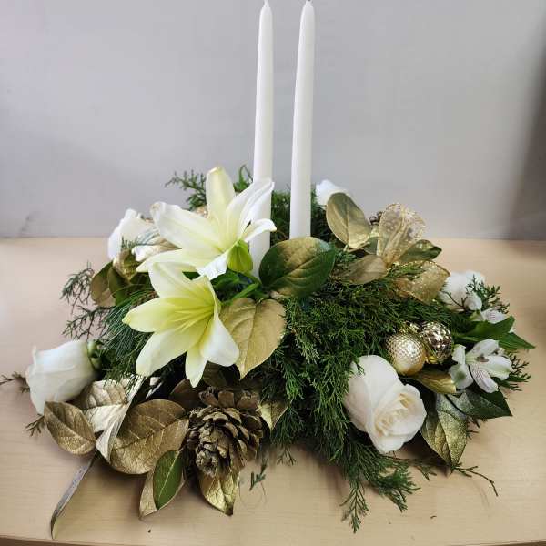 White floral centerpiece with two tall candles and gold accents