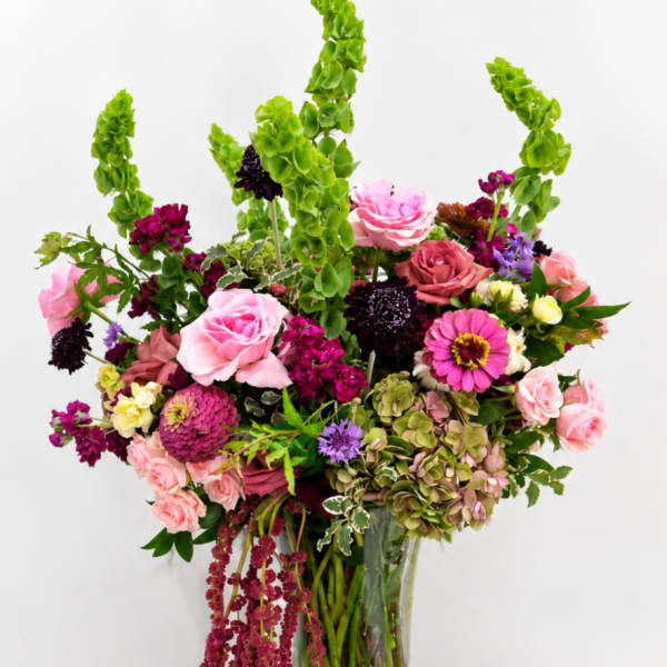 Mixed pink and purple flower arrangement in a glass vase