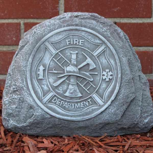 Fire department memorial stone in front of a brick wall