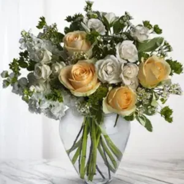 Bouquet of cream and white roses in a clear glass vase