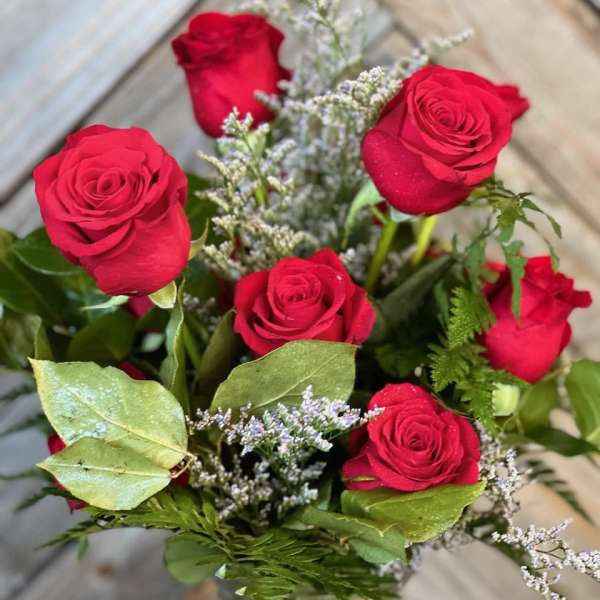 Bouquet of red roses with filler in a glass vase