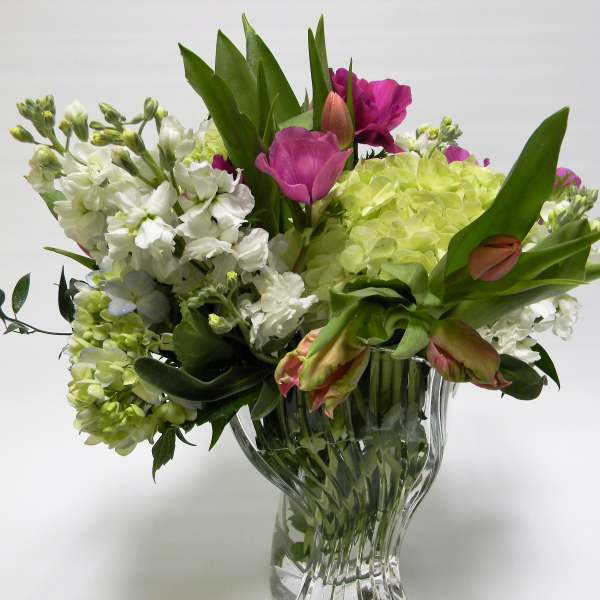 Mixed bouquet of white and pink flowers in a clear glass vase