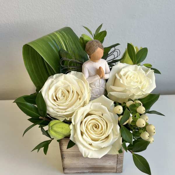 White roses in a wooden box with a small angel figurine