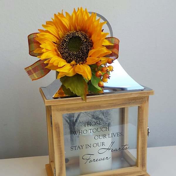 Sunflower arrangement on a wooden memorial lantern with a candle inside