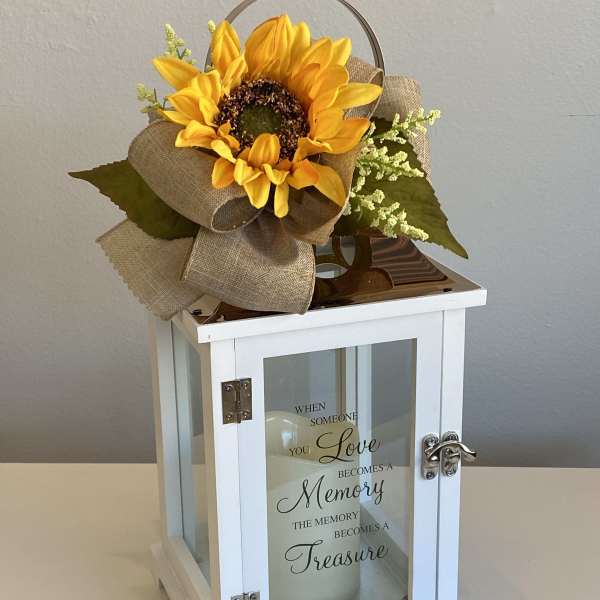 Sunflower arrangement on a white lantern with a memorial quote