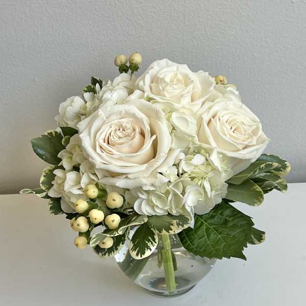 White rose and hydrangea bouquet in a clear glass vase