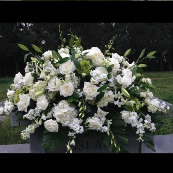White floral casket spray with roses and lilies