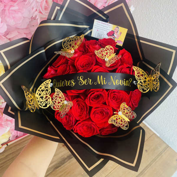 Bouquet of red roses wrapped in black paper with gold butterflies