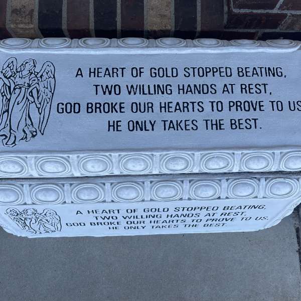 White memorial plaque with an angel illustration and a sympathy verse