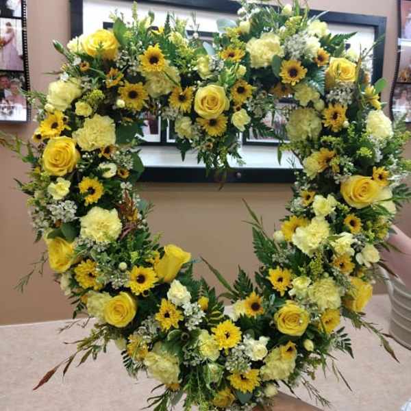 Heart-shaped floral wreath with yellow roses and daisies