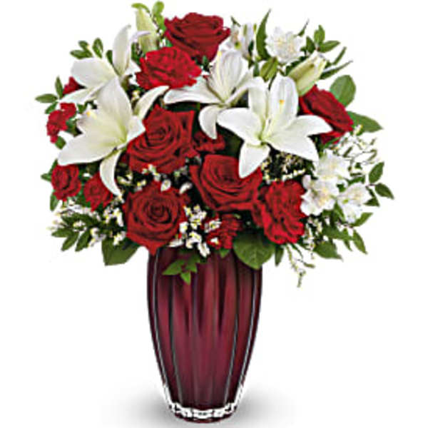 Red roses and white lilies arranged in a tall vase
