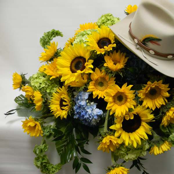 Sunflower arrangement with a beige cowboy hat on top