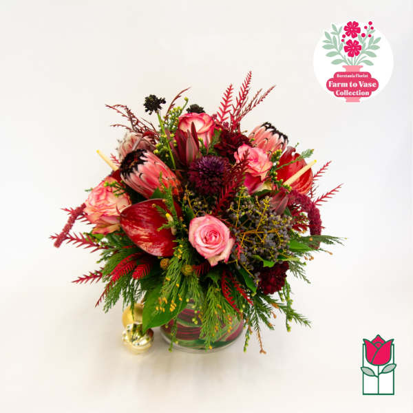Mixed bouquet of pink and red flowers in a glass vase