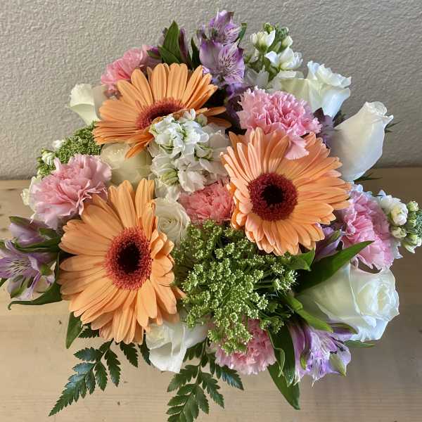Bouquet with orange gerbera daisies, pink carnations, and white roses