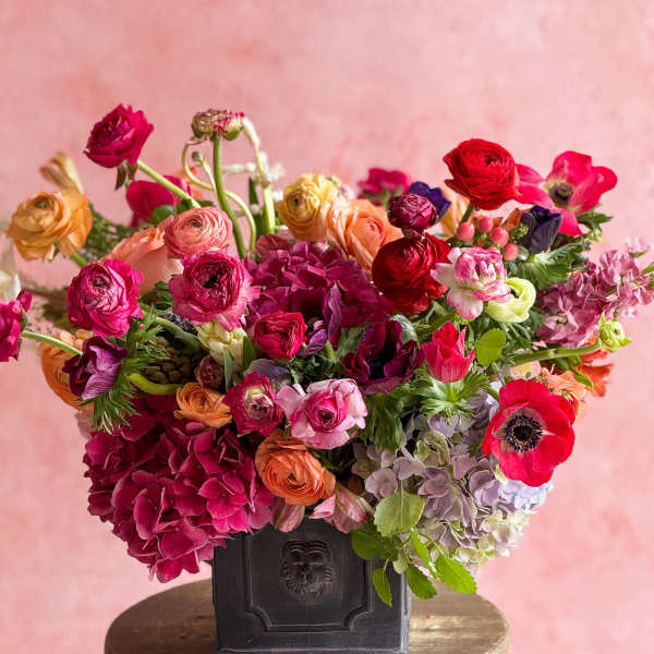 Colorful mixed flower arrangement in a dark vase