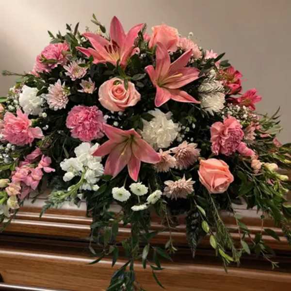Pink and white floral casket spray with lilies and roses