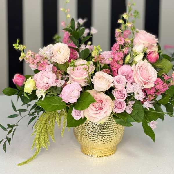 Pink and white floral arrangement in a gold vase