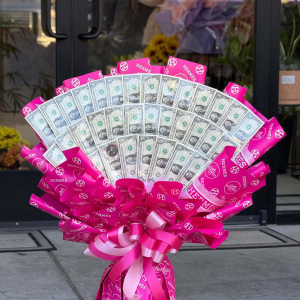 Fan-shaped bouquet of dollar bills wrapped in bright pink ribbon
