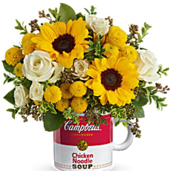 Sunflowers and white roses arranged in a Campbell's soup mug