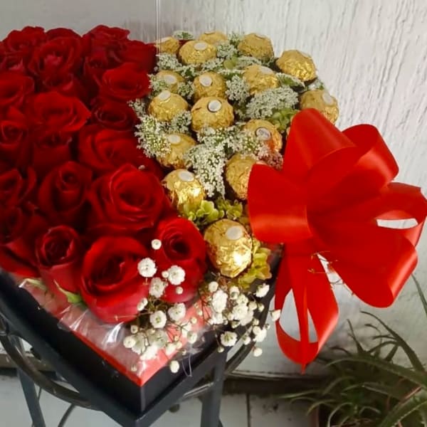 Heart-shaped bouquet of red roses and gold-wrapped chocolates with a red bow