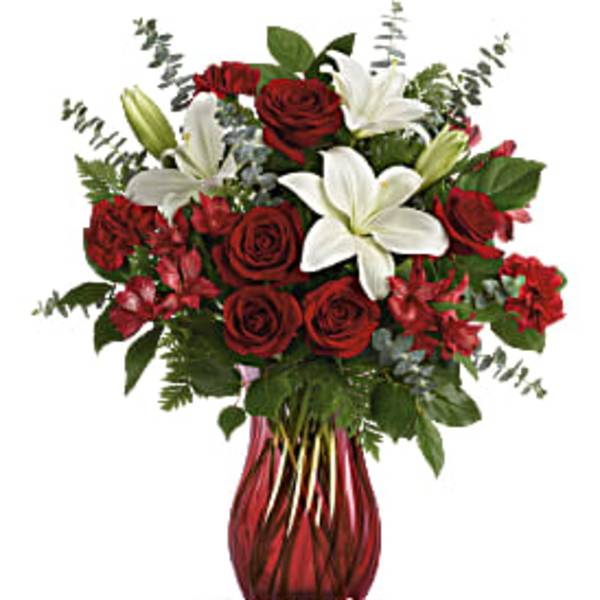 Red roses and white lilies in a red glass vase
