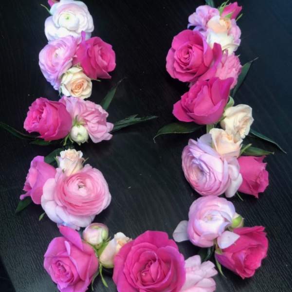 Pink and white floral wrist corsages arranged in a circle
