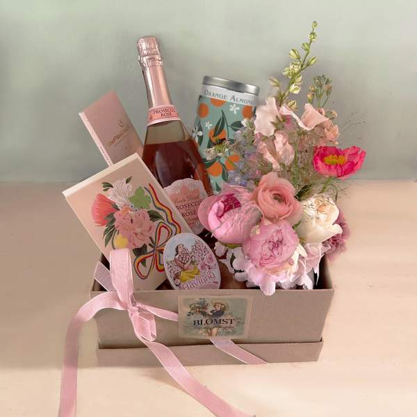 Gift box with pink flowers, a rosé bottle, and chocolates