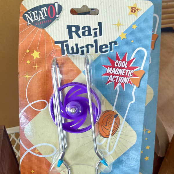 Packaged purple rail twirler toy with metal rods and blue handle