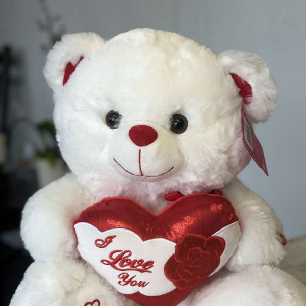 White teddy bear holding a red heart that says I Love You