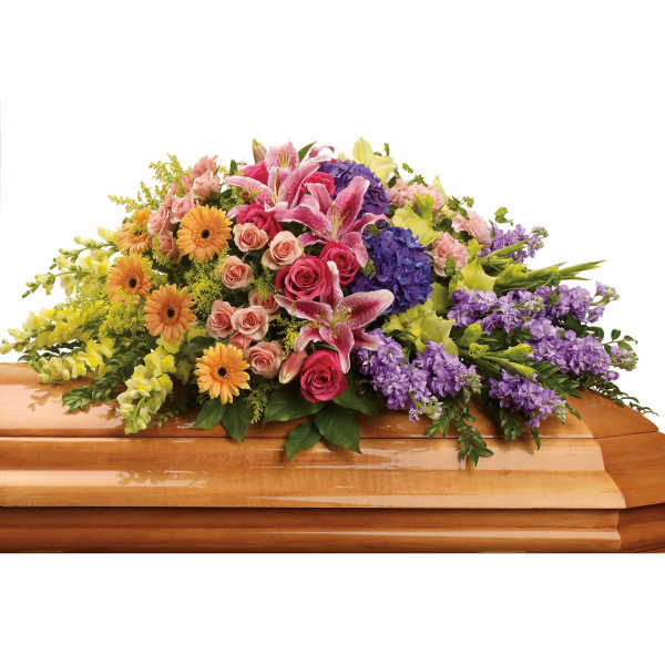 Colorful floral casket spray with lilies, roses, gerberas, and purple blooms