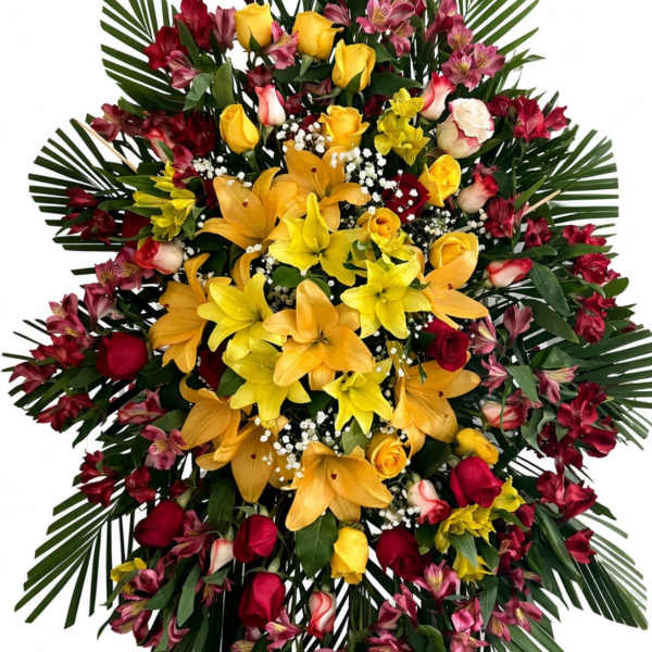 Large standing floral spray with yellow lilies, red roses, and pink blooms