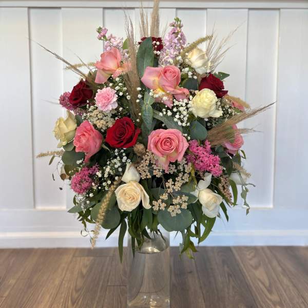 Mixed roses and filler flowers in a clear glass vase