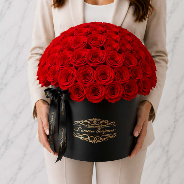 Woman holding a large red rose arrangement in a black hat box