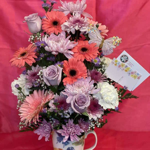Lavender and pink mixed bouquet in a floral mug vase with butterfly accents