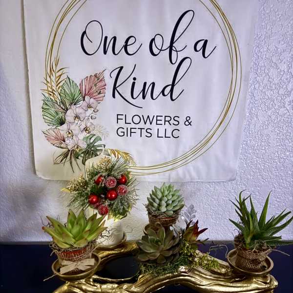 Succulent arrangement on a gold tray with a small decorated candle