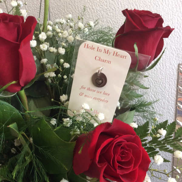 Red roses with baby's breath and a memorial charm card