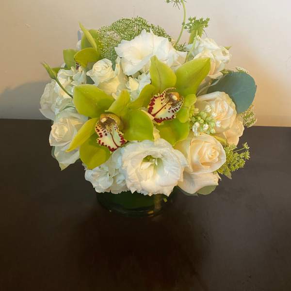 White and green floral arrangement in a glass vase
