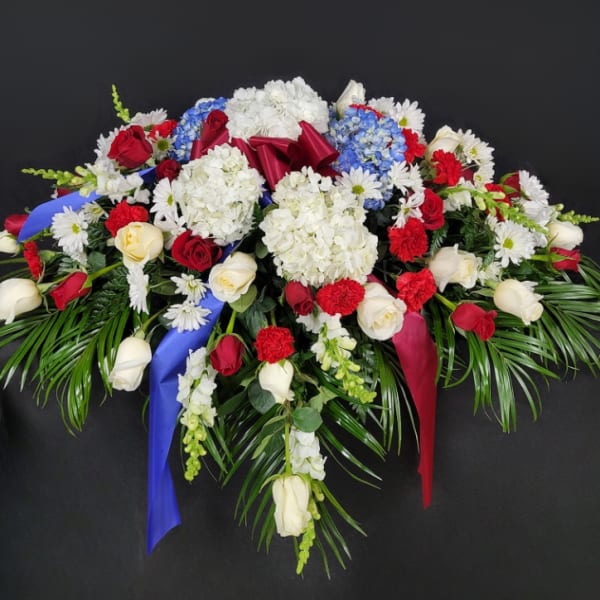 Large floral spray with red and white roses, hydrangeas, and daisies