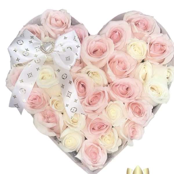 Heart-shaped bouquet of pale pink and white roses with a decorative ribbon