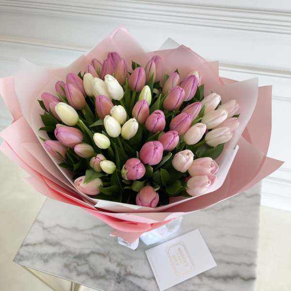 Bouquet of pink and white tulips wrapped in pink paper