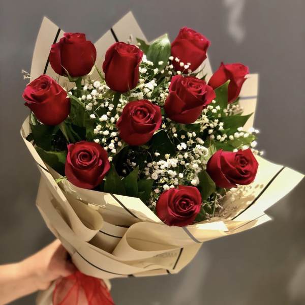 Bouquet of red roses with baby's breath in beige wrapping