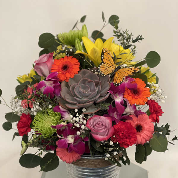 Mixed bouquet in a metal vase with a butterfly accent