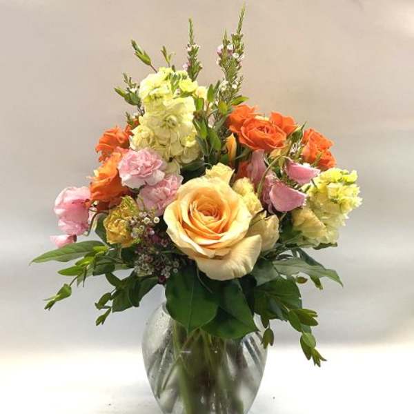 Mixed bouquet of roses and carnations in a clear glass vase