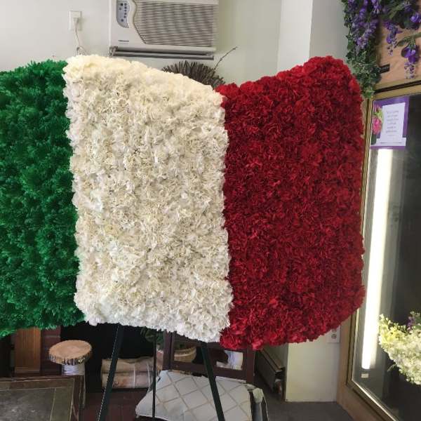 Floral display in green, white, and red arranged like a flag on an easel